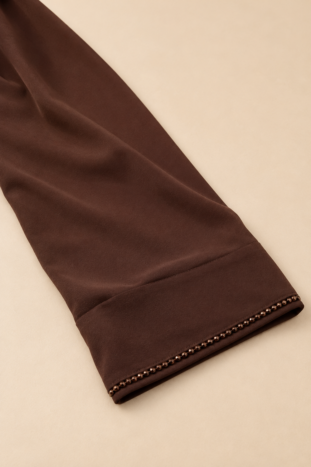 Abaya Fleurie — Chocolat : détail de la bordure perlée et de la finition du poignet