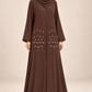 Abaya Bourgeons chocolat portée de trois quarts, coupe longue et manches perlées.