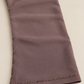 Détail de la manche taupe : fine bordure de perles facettées et ourlet cousu.