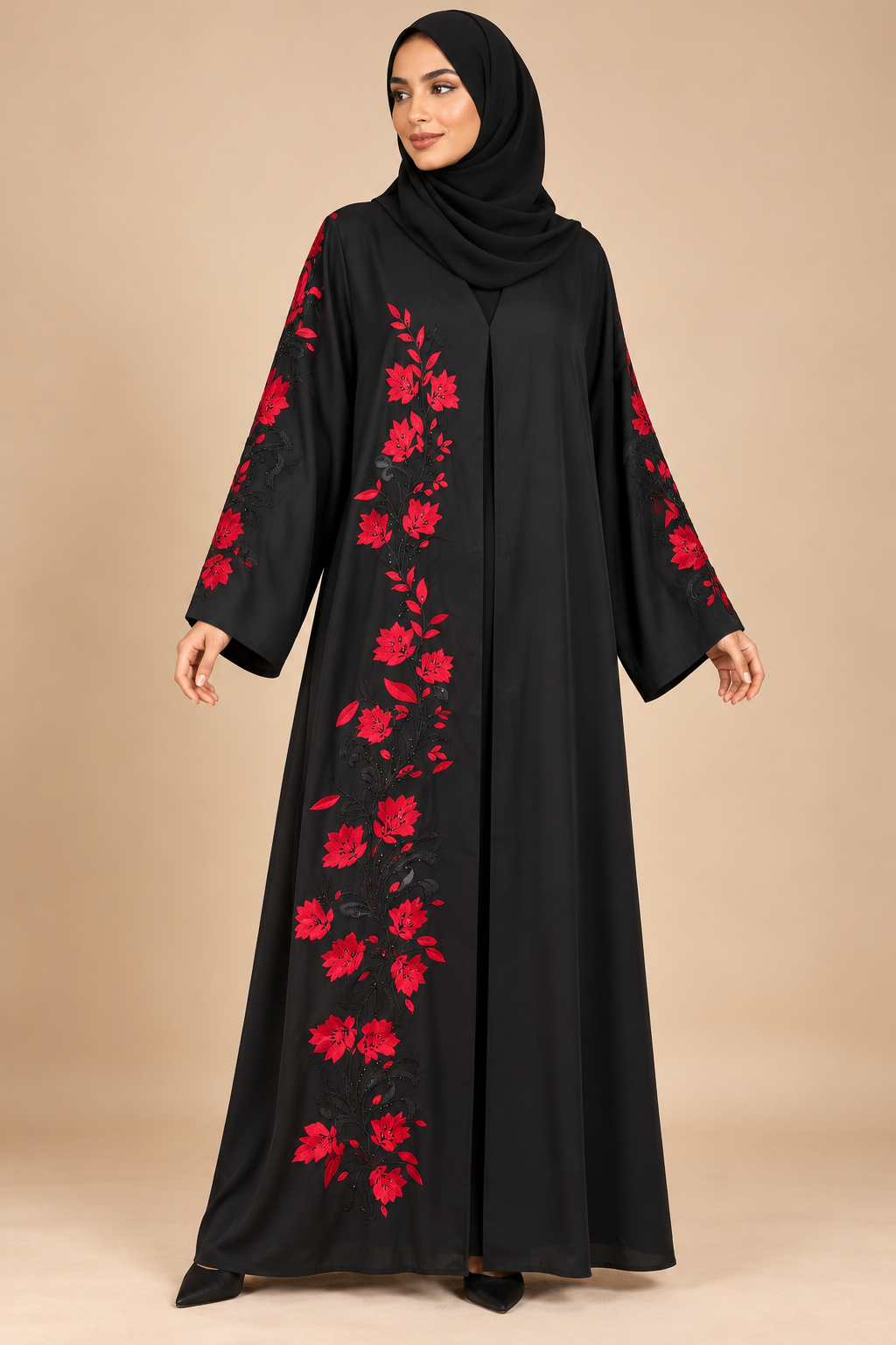 Abaya noire à broderies rouges portée par une mannequin métisse arabe, voile couvrant la poitrine