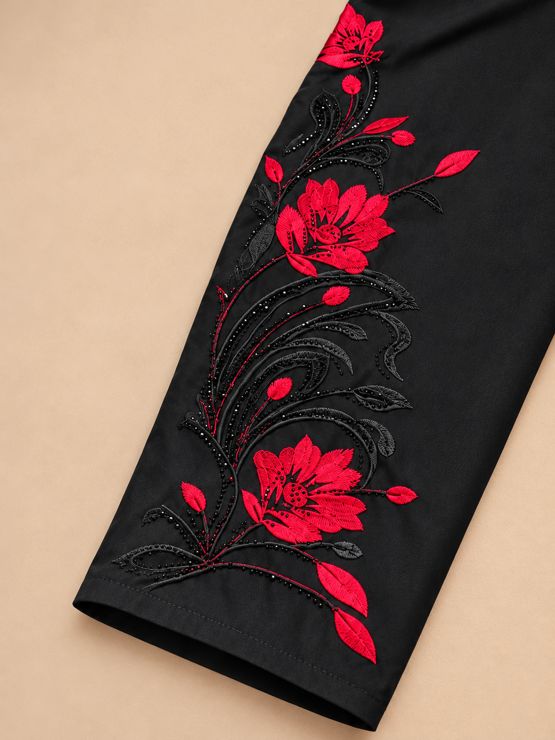 Détail de la manche brodée rouge et de la finition du poignet