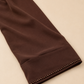 Abaya Fleurie — Chocolat : détail de la bordure perlée et de la finition du poignet