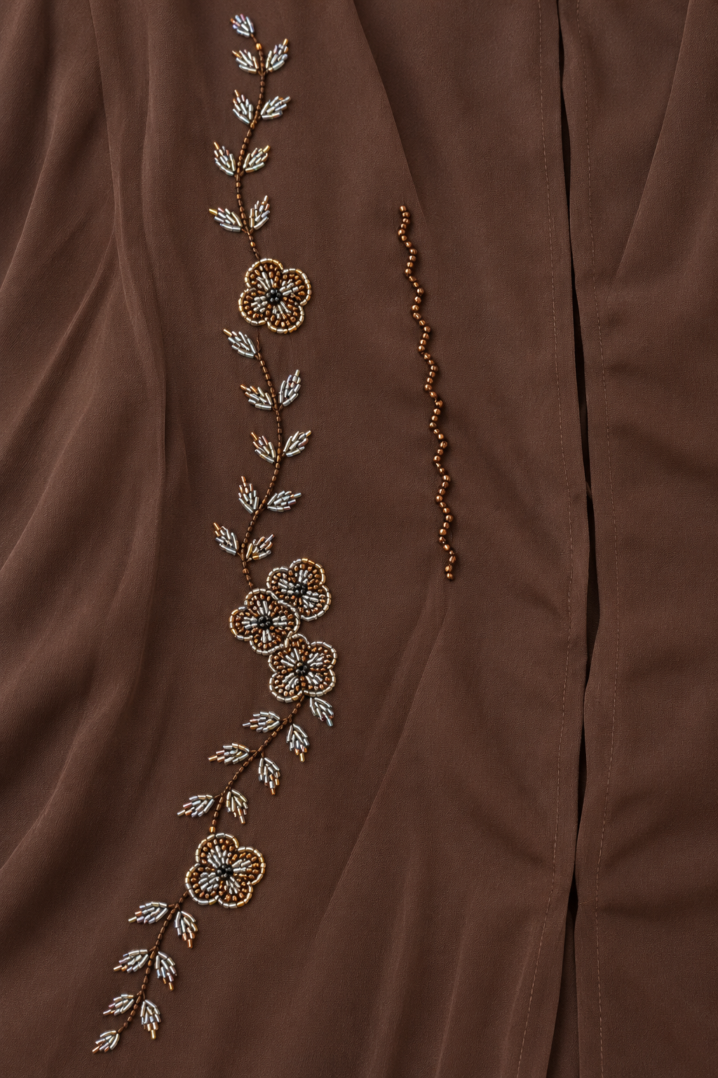 Abaya Fleurie — Chocolat : gros plan sur les fleurs, feuilles perlées et lignes ondulées