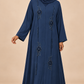 Abaya Ondes bleue portée par une mannequin arabe au teint hâlé, voile couvrant la poitrine