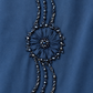 Détail du motif circulaire et des ornements perlés de l’abaya bleue