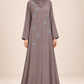 Abaya Roseraie taupe portée par une mannequin métisse arabe à la silhouette élancée, voile couvrant la poitrine
