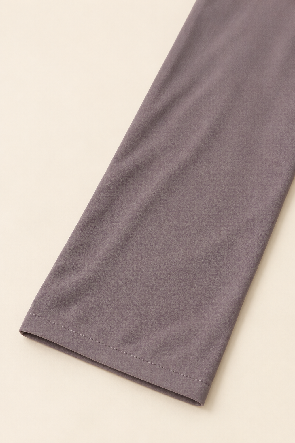 Détail de la manche unie taupe et de son ourlet surpiqué