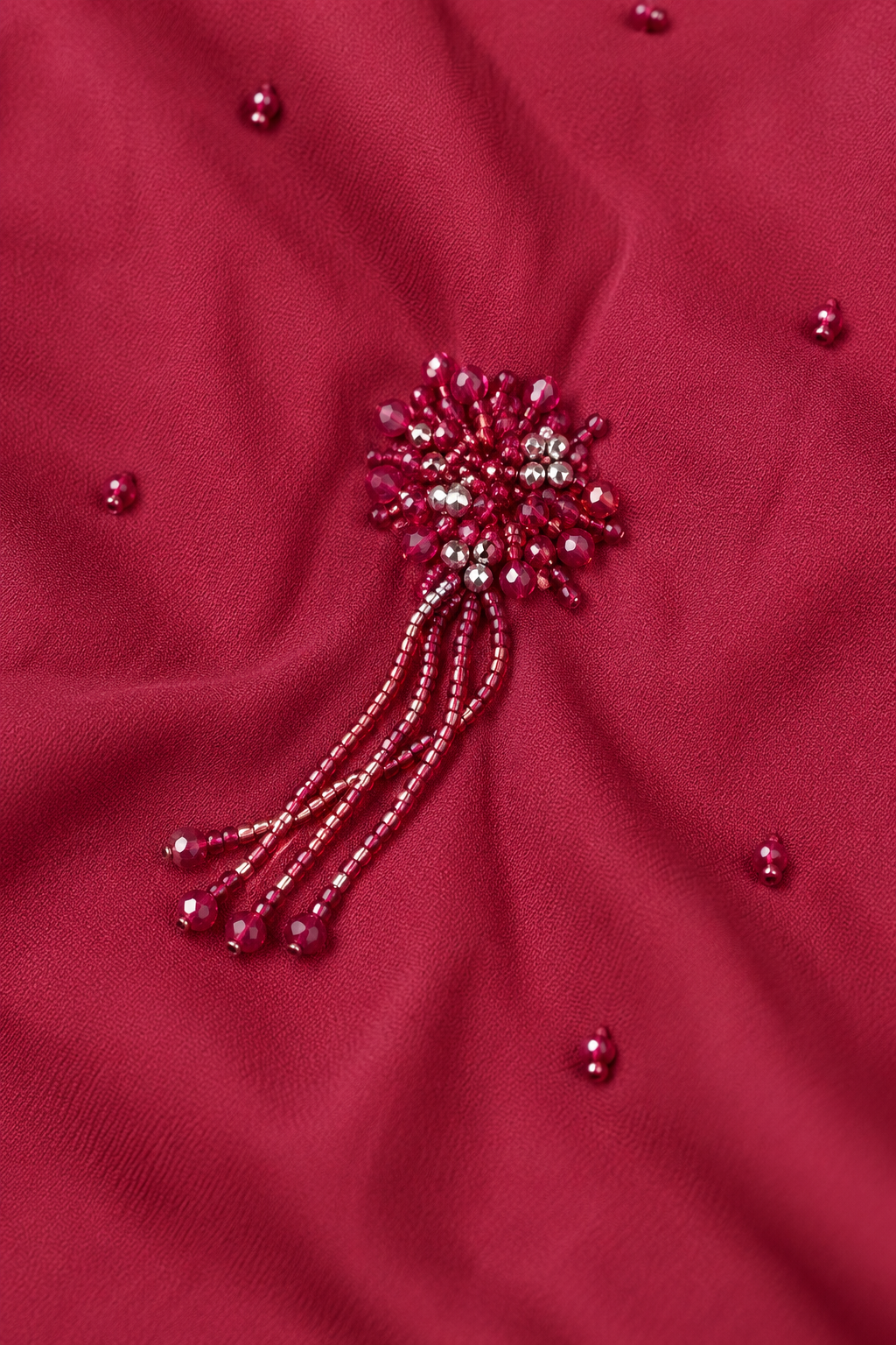 Détail du motif floral perlé bordeaux et de ses fines franges