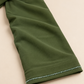 Détail du poignet de l’abaya Volutes vert olive, bordure perlée et finition de l’ourlet